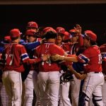 Baseball team celebrating near the dugout.